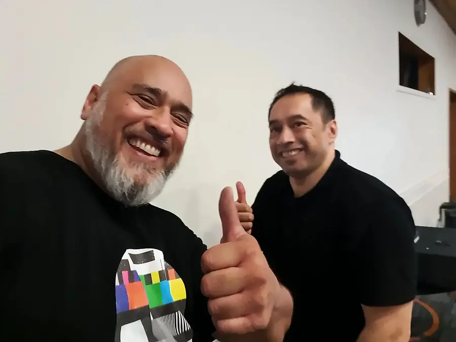 Two Manaia Go team members smiling and giving a thumbs up at a venue
