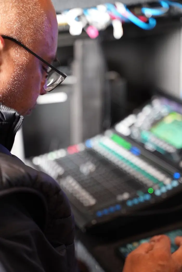 Audio engineer working a digital mixing desk inside the truck